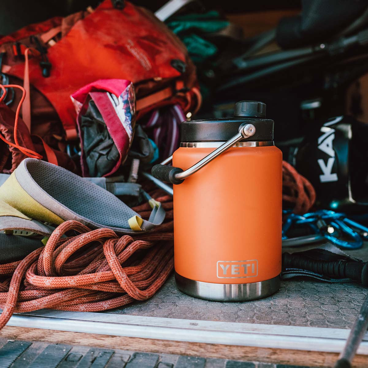 Yeti Rambler Half Gallon Jug Open Lifestyle Image in King Crab Orange