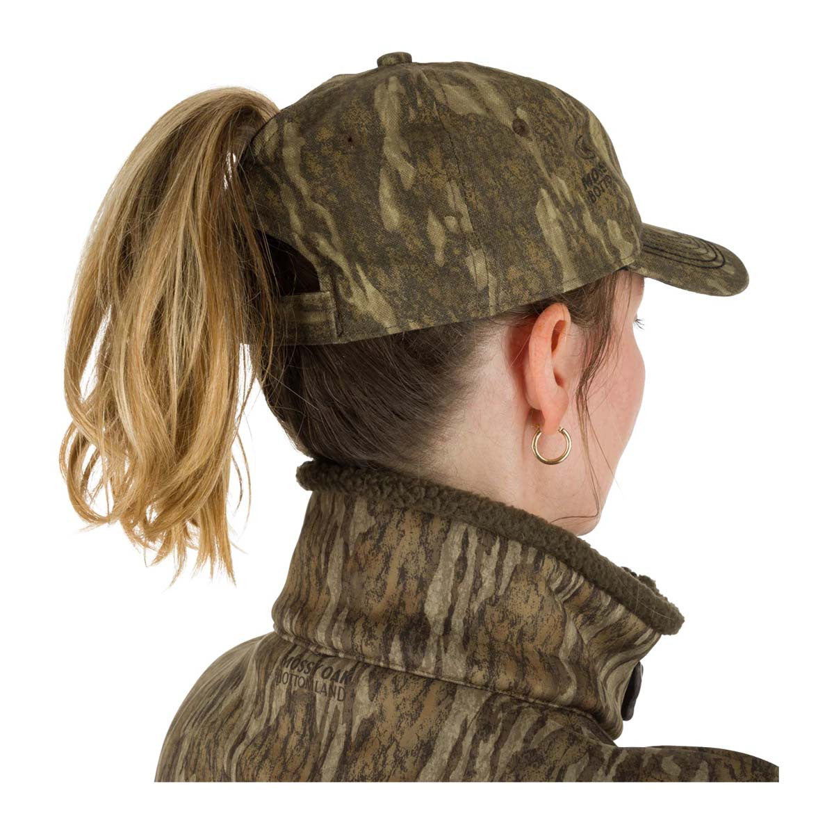 Drake Waterfowl Women's Camo Ponytail Cap Lifestyle Image in Mossy Oak Bottomland